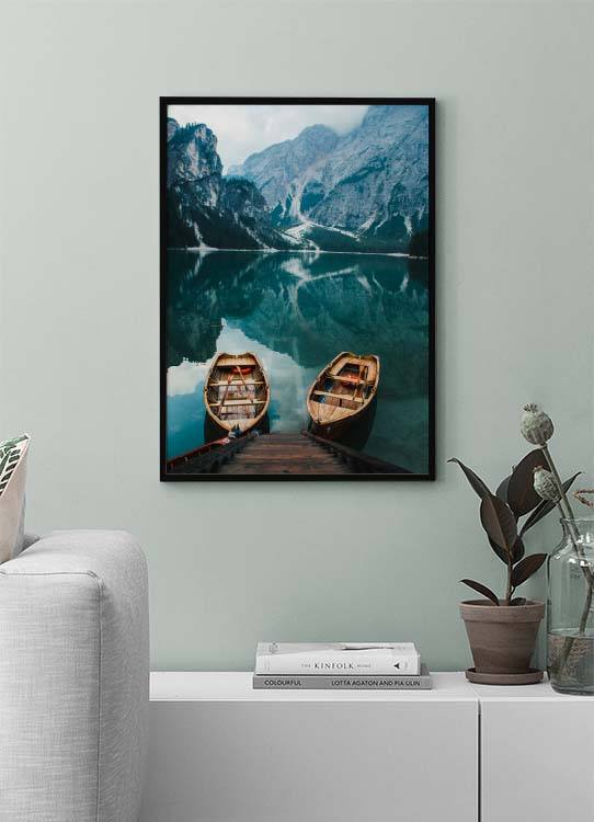  – Photographie de deux bateaux dans un lac avec des montagnes brumeuses à l’arrière-plan