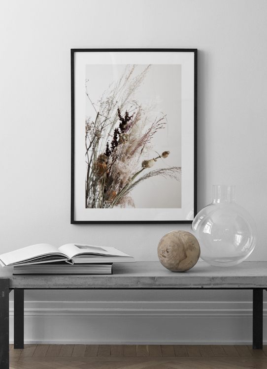  – Photographie d’un bouquet de fleurs séchées et d’herbe sèche sur un fond gris clair