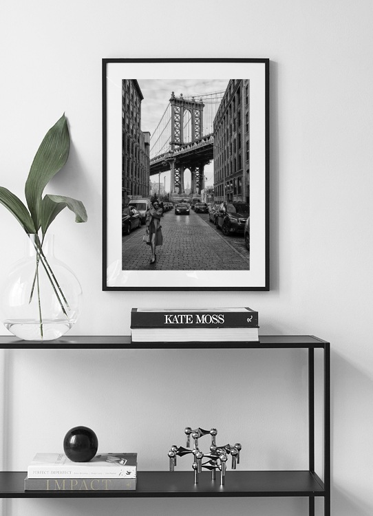  – Photographie en noir et blanc d’une femme dans une rue de New York devant le pont de Manhattan