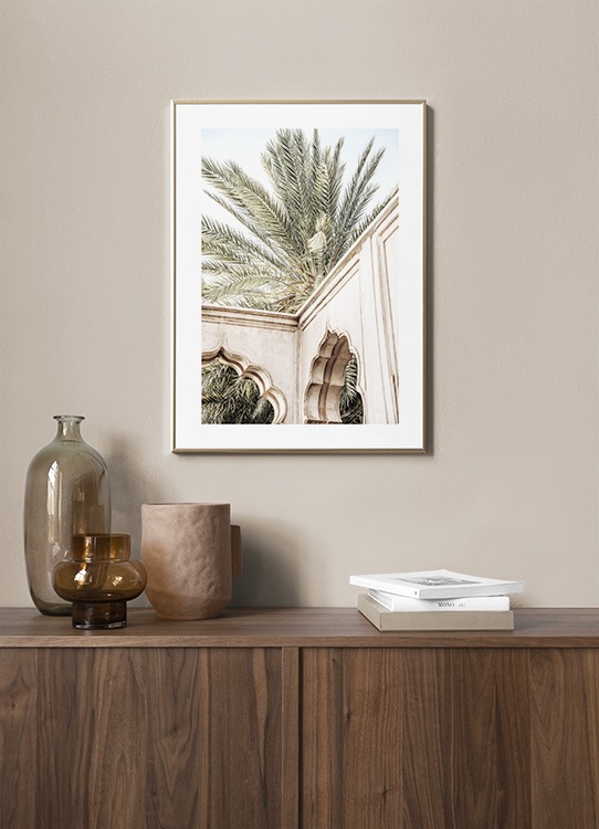  - Fotografie eines beigen Gebäudes mit geschwungenen Bögen vor einer Palme